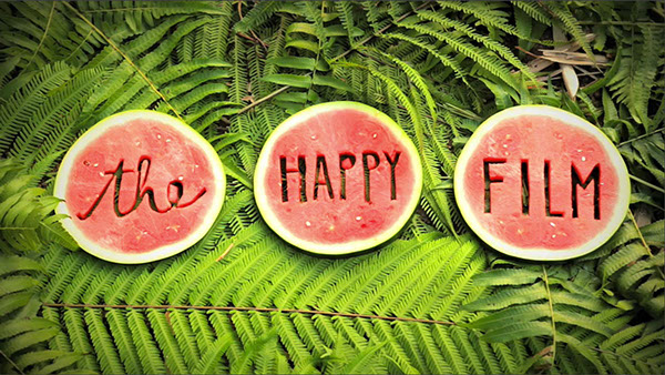 Three watermelon slices with "the happy film" carved into them