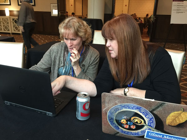The speaker’s table was a hot spot where attendees could get some one-on-one time with speakers like Claudia McCue (right), finding solutions to tricky InDesign problems.