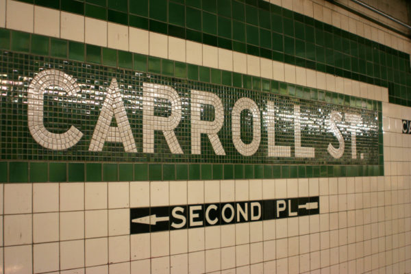 Wall of subway tiles with "Carroll St." 