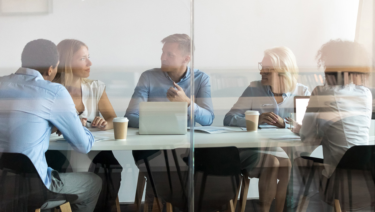photo of four people having a meeting in a an office conference room