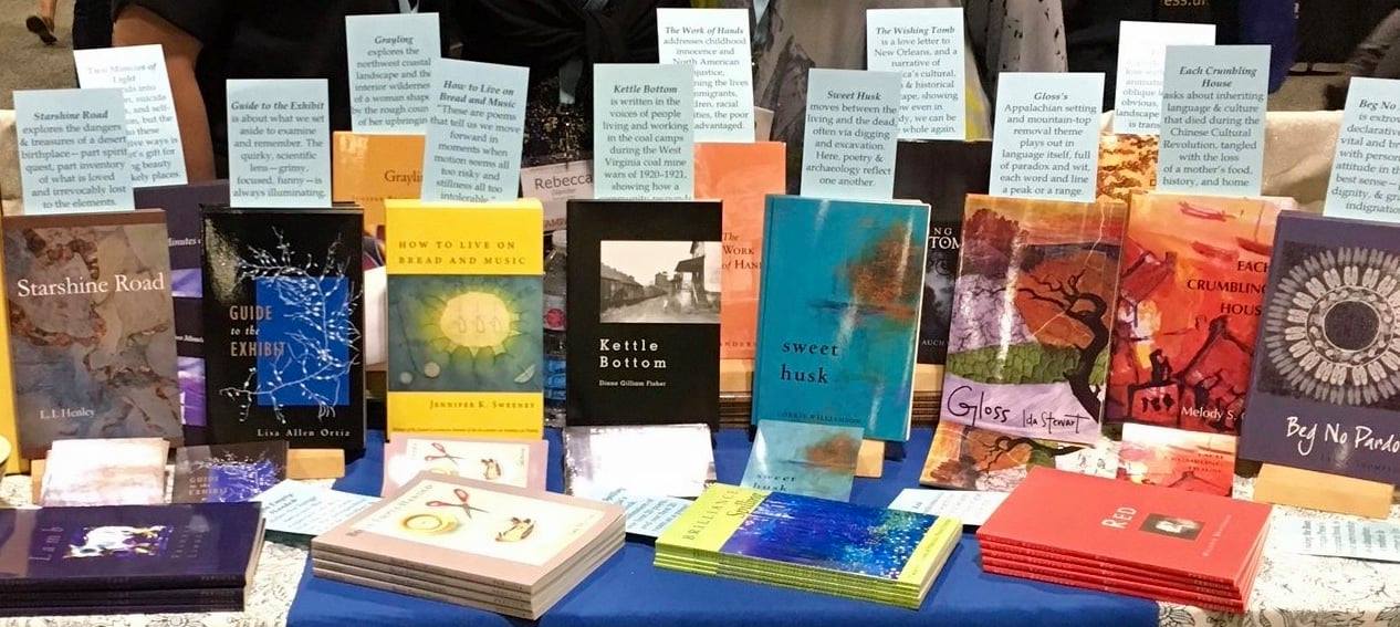 A table displays approximately 10 paperback books with color covers, each displaying an accolade from a reviewer.