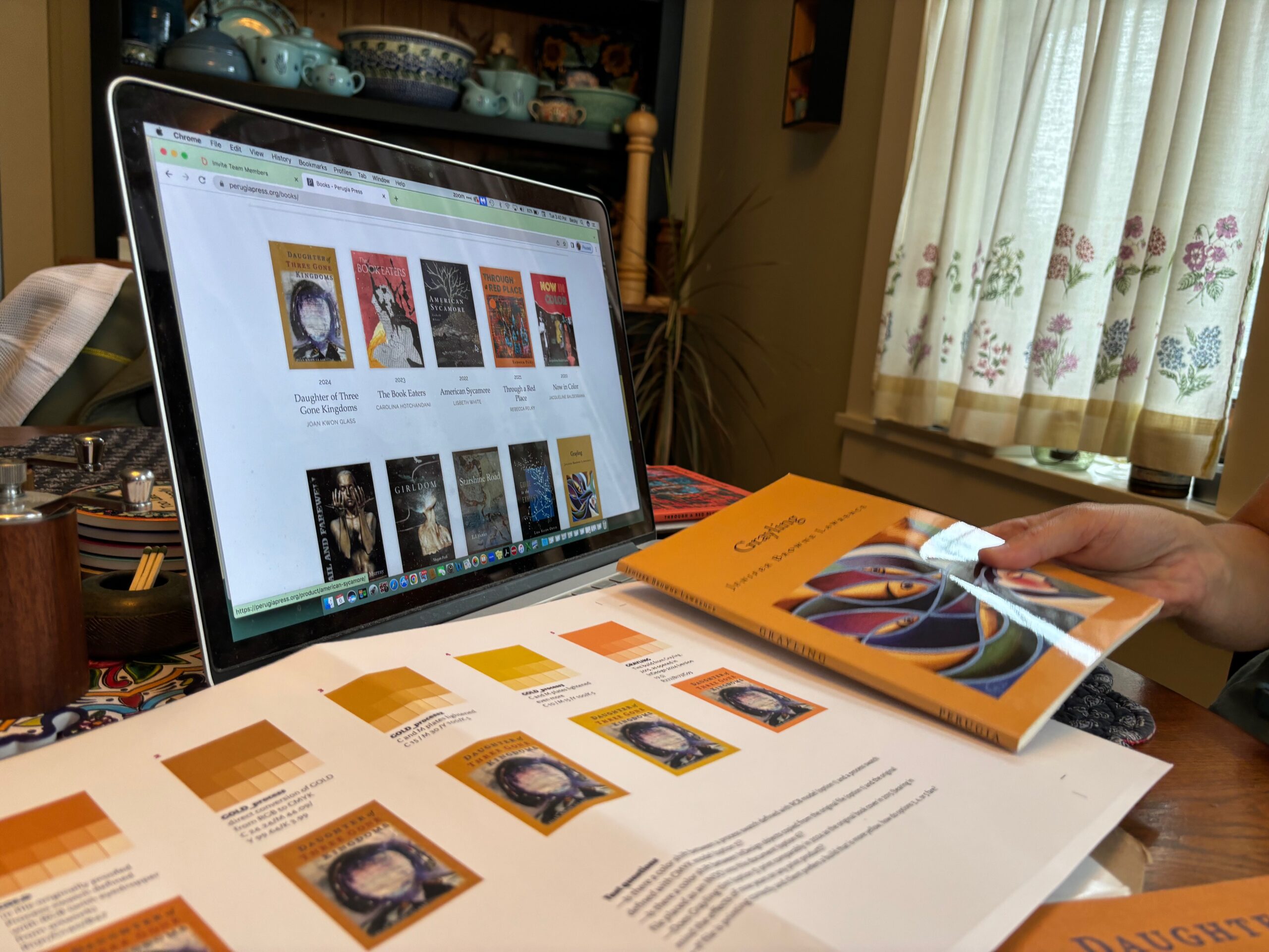 The book Grayling juxtaposed against the proof of the cover, with a laptop on a table showing a web page of book covers