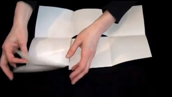 two hands folding blank piece of paper into snake-fold brochure.